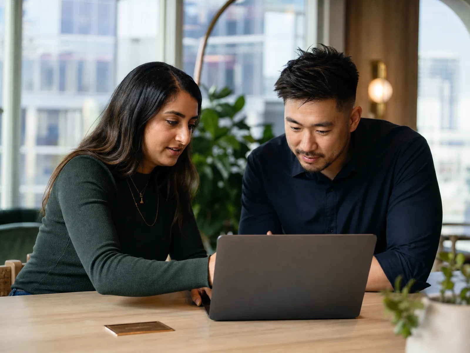 Two colleagues collaborating over a laptop in a modern Edmonton workplace in 2026